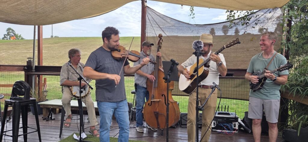 A photo of members of the Mill Hands performing outside.